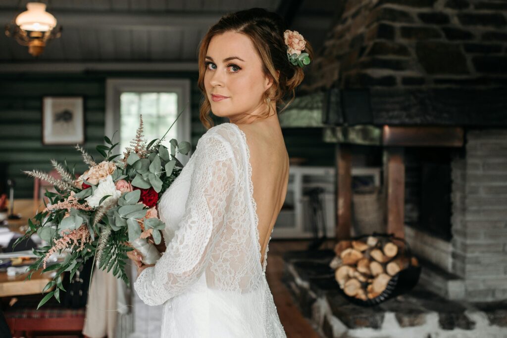 Fall micro wedding outdoor ceremony aisle with wooden arch and autumn florals in soft dayligh